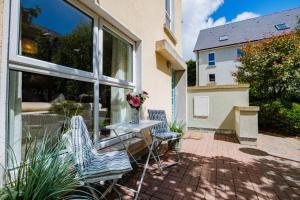 a patio with two chairs and a table with a vase of flowers at City Townhouse with parking in Galway