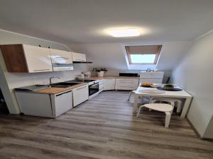 a small kitchen with white cabinets and a table at Apartment in Stepnica near Szczecin Lagoon in Stepnica +21 photos
