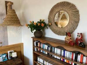 ein Spiegel und ein Bücherregal mit Büchern in der Unterkunft Chambre d'hôte Les Oulies Bédoin in Bédoin
