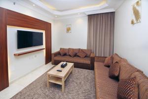a living room with a couch and a tv at Ghima Jeddah in Jeddah +26 photos