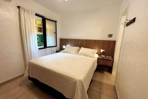 a bedroom with a bed and a window at Praia da Baleia | Frente ao Mar c/ Quiosque in São Sebastião