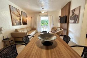 a living room with a wooden table and chairs at Praia da Baleia | Frente ao Mar c/ Quiosque in São Sebastião