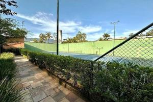 a tennis court with a fence and a tennis at Praia da Baleia | Frente ao Mar c/ Quiosque in São Sebastião +13 photos