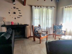 sala de estar con chimenea y reloj en la pared en Chalet con Piscina exclusiva en el centro de Mar de las Pampas, en Mar de las Pampas