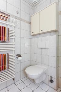 a bathroom with a toilet and a cabinet and towels at Bensersiel Ferienwohnung Kapitän mit Terrasse und Garten in Bensersiel