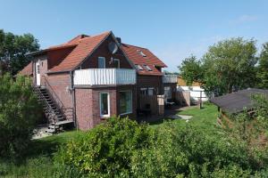 an old brick house with a red roof at Bensersiel Ferienwohnung Kapitän mit Terrasse und Garten in Bensersiel