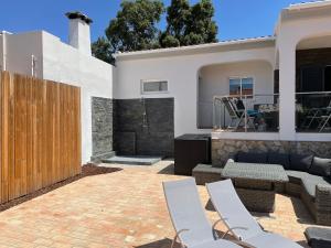 a patio with chairs and a wooden fence at Ville Verde in Loulé