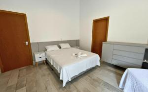 a bedroom with a bed with two white pillows at Casa 14 · 4 Suítes | Piscina Privativa e Serviço De Praia in São Sebastião