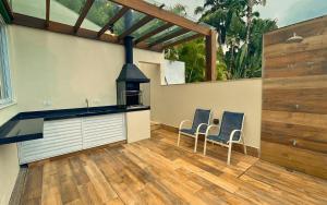 a kitchen with two chairs and a stove at Casa 14 · 4 Suítes | Piscina Privativa e Serviço De Praia in São Sebastião +47 photos