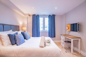 a bedroom with a large bed with blue curtains at Harbour View in Galway