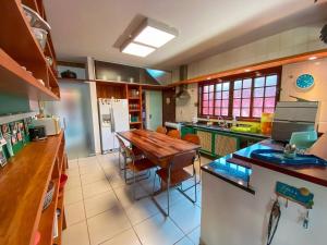 eine große Küche mit einem Holztisch darin in der Unterkunft Casa Paraiso Praiano 2 minutos da praia · Barra do Una | Paraíso praiano a 120m da praia in São Sebastião