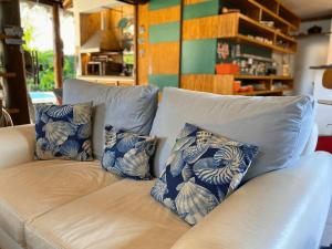 ein Sofa mit vier blauen und weißen Kissen darauf in der Unterkunft Casa Paraiso Praiano 2 minutos da praia · Barra do Una | Paraíso praiano a 120m da praia in São Sebastião
