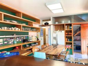 eine Küche mit Tisch und Stühlen und einem Kühlschrank in der Unterkunft Casa Paraiso Praiano 2 minutos da praia · Barra do Una | Paraíso praiano a 120m da praia in São Sebastião + 29 Fotos