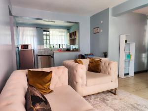 a living room with a couch and a kitchen at Serenity Stays Nairobi in Nairobi +90 photos
