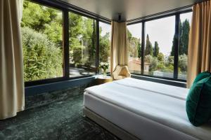 a bedroom with a bed and large windows at EZE BEACH Residence in Éze