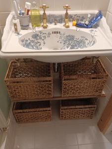 ein Badezimmer mit Waschbecken und Körben darunter in der Unterkunft Chambre d'hôte Les Oulies Bédoin in Bédoin