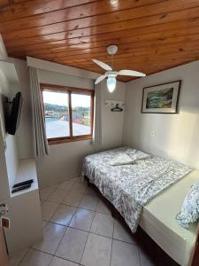 a bedroom with a bed and a wooden ceiling at Pousada Angela in Urubici