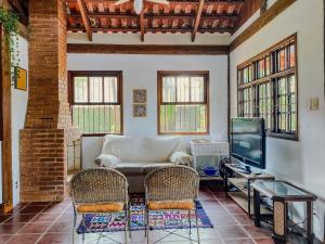 a living room with a couch and chairs and a tv at Casa Esperança Praiana - Ideal para... · Juquehy | Casa Esperança Praiana ideal p/ crianças in São Sebastião