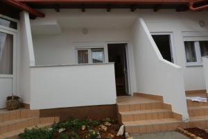 a house with a staircase leading to the front door at Pansion Comfort Sidro in Novalja