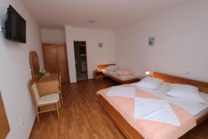 a bedroom with a large bed and a chair at Pansion Comfort Sidro in Novalja
