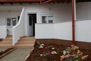 a garden in front of a house with flowers at Pansion Comfort Sidro in Novalja