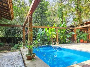 a swimming pool in the middle of a garden at Rua Borba Gato Nº 115 · Casa da Mata - An Experience Amidst Nature in São Sebastião +77 photos