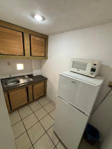 a kitchen with a microwave on top of a refrigerator at Laguna 02 in Tampico