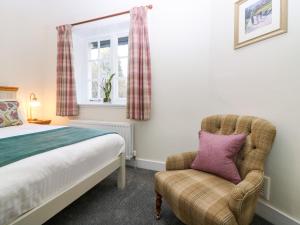 une chambre avec un lit, une chaise et une fenêtre dans l'établissement East Cottage - Tarvit, à Cupar