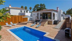 a swimming pool in front of a house at Ville Verde in Loulé