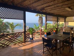 un tavolo e delle sedie su un ponte con vista sull'oceano di Tropikal House Facing Ocean a Vila do Maio