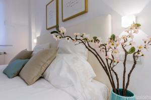 a bedroom with a bed with a vase with flowers at Center Pamplona Apartment UAT00537 in Pamplona
