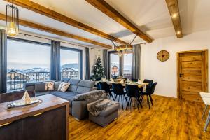 a living room with a couch and a table with chairs at Chata Wellness Liptov in Ižipovce