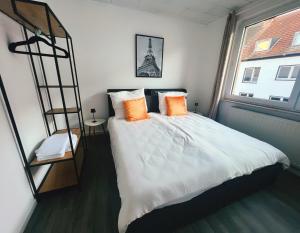 a bedroom with a bed with orange pillows and a ladder at Wohngut City Appartement 4 für 1-4 Personen inklusive Parkplatz in Hagen