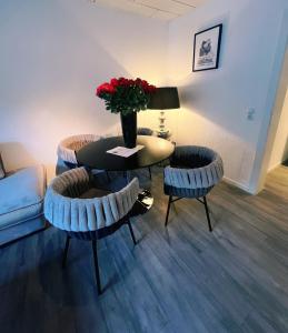 a living room with a table and chairs with a vase of flowers at Wohngut City Appartement 4 für 1-4 Personen inklusive Parkplatz in Hagen