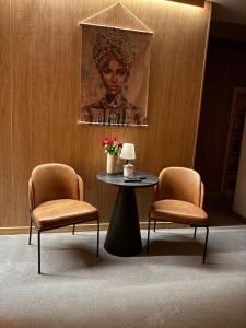 a room with two chairs and a table and a painting at R34 Boutique Guest House in Veliko Tŭrnovo