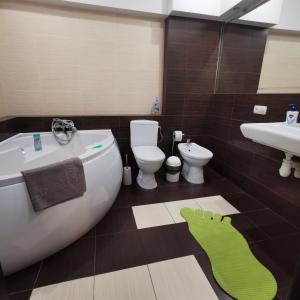 a bathroom with a tub and a toilet and a sink at Big Apartment in Rivne center in Rivne +27 photos