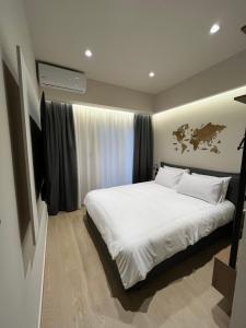 a bedroom with a white bed with a map on the wall at Serenity Luxury Apartment in Alexandroupoli