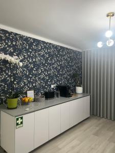 a kitchen with a counter with a floral wallpaper at White Guest in Fátima