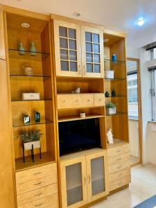 a living room with wooden shelves and a tv at Estúdio aconchegante na Alberto Braune in Nova Friburgo