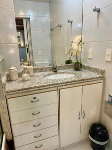 a bathroom with a sink and a mirror at Estúdio aconchegante na Alberto Braune in Nova Friburgo +14 photos