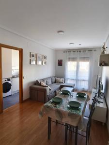 ein Wohnzimmer mit Tisch und Couch in der Unterkunft apartamento familiar con piscina licencia 14721 in Camarma de Esteruelas