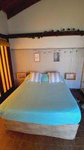 a large bed with two pillows on top of it at Quincholoftmdq monoambiente con cochera in Mar del Plata