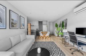 メルボルンにあるLuxurious 3- Bedroom Retreatのソファとテーブルのあるリビングルーム