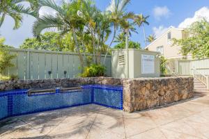 a swimming pool in a yard with a fence and palm trees at The Drifter - North Shore Loft - Relaxed Luxury in Kahuku