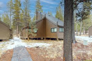 una casa en el bosque con un árbol en Cozy Cabin, en Sunriver
