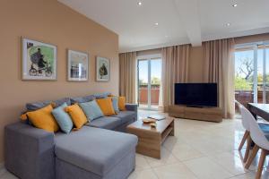 a living room with a couch and a flat screen tv at Lia's Home Two in Mantoúkion