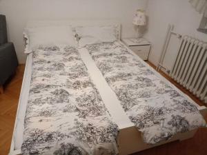 ein Bett mit einer schwarz-weißen Decke drauf in der Unterkunft Kleopa in Pale