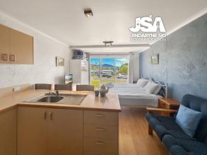 a kitchen with a sink and a bed in a room at Parkwood 3 in Jindabyne
