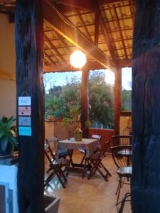 a table and chairs on a patio with a table and chairs at Chalé do João e do Chico Garfield in Jaboticatubas