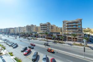 une rue de la ville avec des voitures garées dans un parking dans l'établissement scandic resort 523, à Hurghada